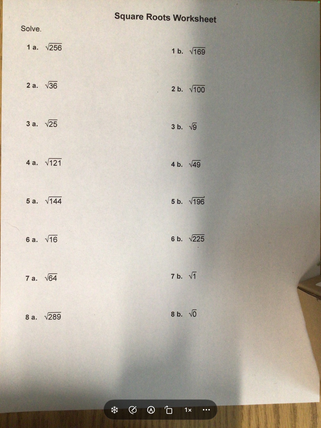 The live camera view showing a square roots worksheet, with a slim floating control bar at the bottom of the screen.